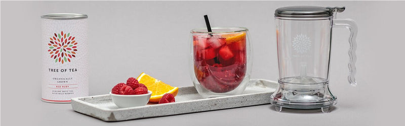 Raspberry Ruby Cocktail auf einem Tablett mit dem Teamaker daneben