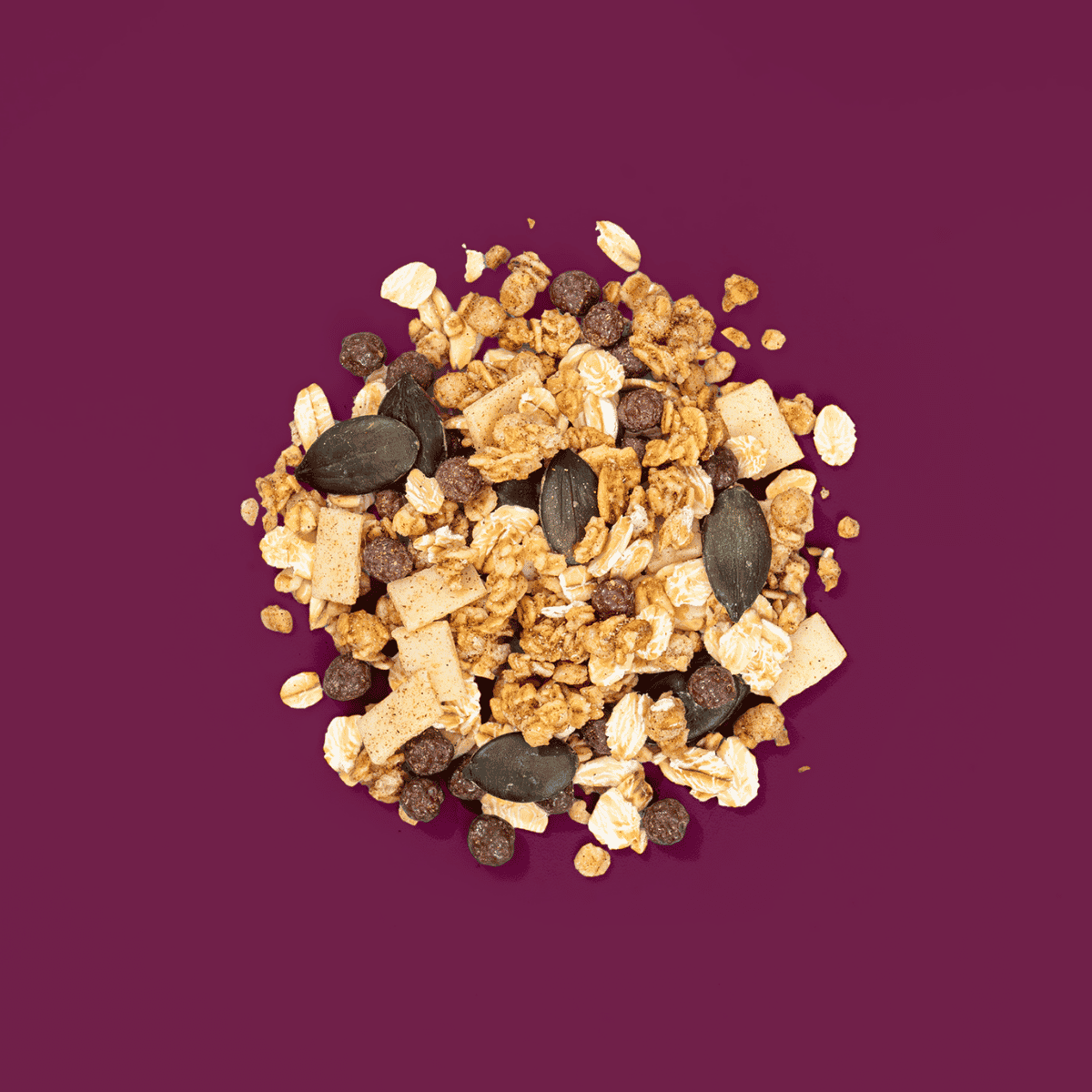 Ein Müsli Haufen mit Kürbiskernen, Haferflocken und weißer Schokolade.