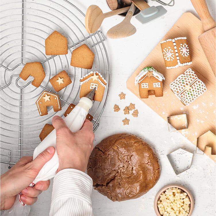 Christmas Cookie Spekulatiusdorf werden mit Zuckerguss verziert