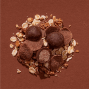 Detailaufnahme der Mozart-Müsli-Zutaten wie Mozartkugeln, Mandeln und Haselnüssen.