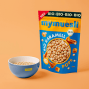 mymuesli Bio Karamell Pops Verpackung neben Schale mit Pops in Milch