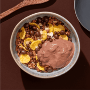 mymuesli Bio Choco Brownie Müsli mit Browniekeksen in Müslischüssel mit Joghurt