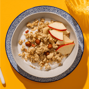 mymuesli Bio Low Sugar Roasted Nuts Müsli in Schale mit Joghurt und frischen Äpfeln