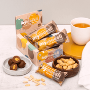 Lifestyle-Aufnahme der Erdnuss-Nut-Butter-Balls neben frischen Erdnüssen auf einer Arbeitsfläche.
