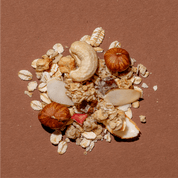 Detailansicht der Honey & Nuts Müsli-Mischung mit Fokus auf ganzen Cashewkernen, Haselnüssen und Haferflocken auf Braun.