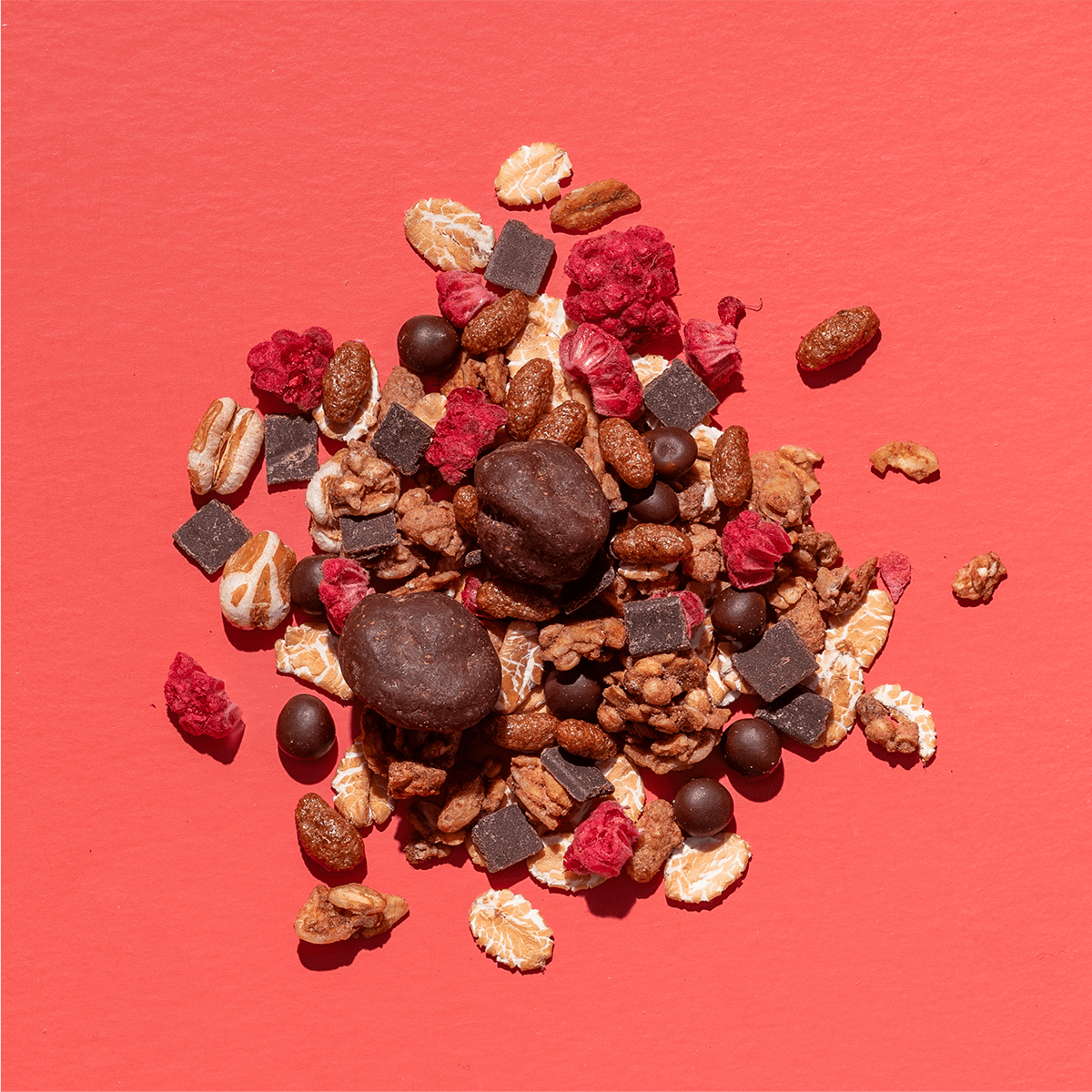mymuesli Bio Raspberry Dark Choc besteht aus Kakao Quinoa Crunchy, dunkle Schoko Dinkelbällchen, gefriergetrocknete Himbeeren, Dinkelflocken, dunkle Schokolade, dunkle Cranberry Chocs und gepuffter Dinkel