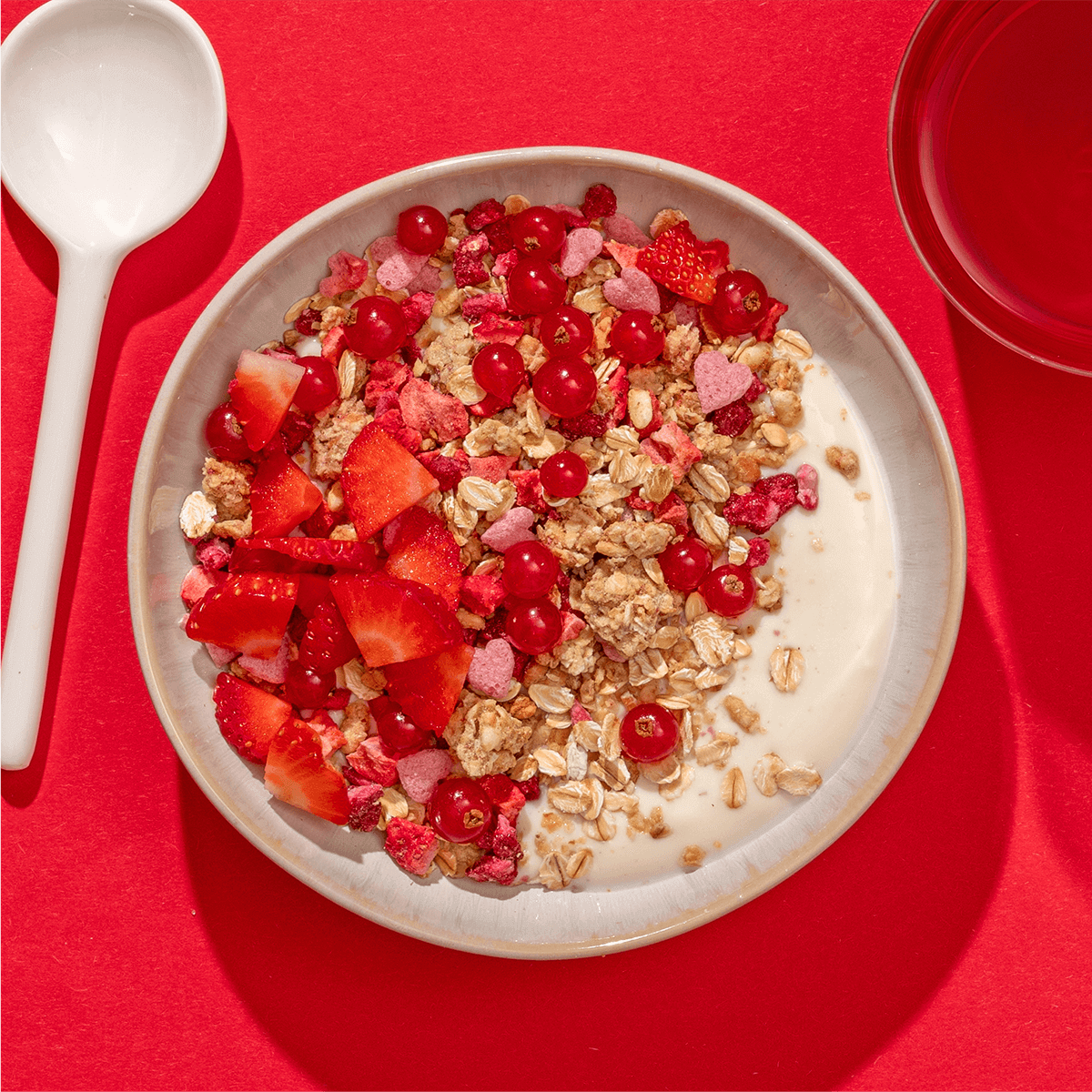 Eine Schüssel Low Sugar Berry Müsli mit Erdbeeren und Johannisbeeren