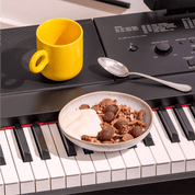 Mozart Müsli in einer stimmungsvollen Frühstücksszene: Schüssel steht auf einem Klavier.