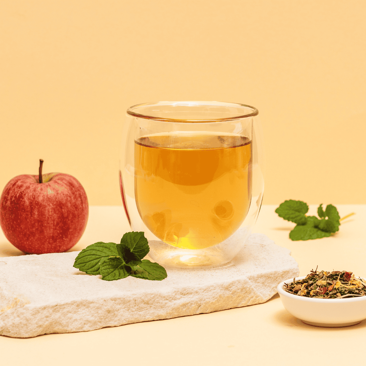 Eine Tasse frisch aufgebrühter Garden Blossom Kräutertee mit floraler Dekoration.