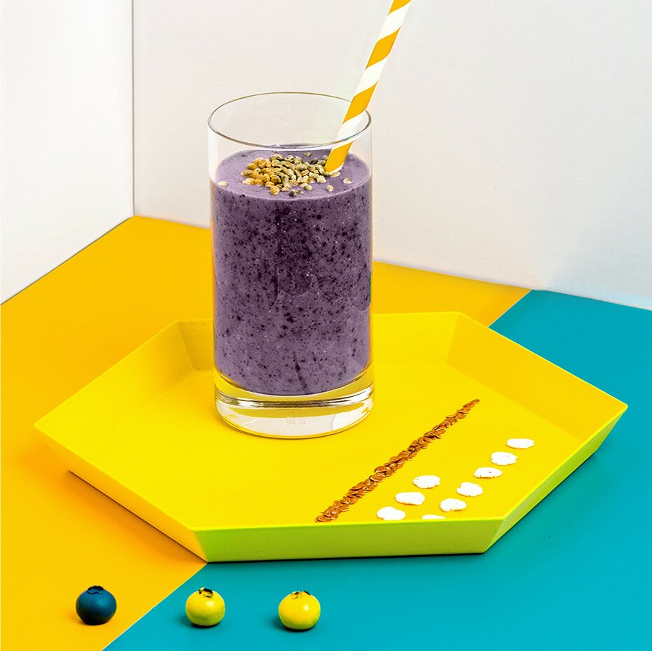 Protein Smoothie auf einem Teller mit einem Strohhalm